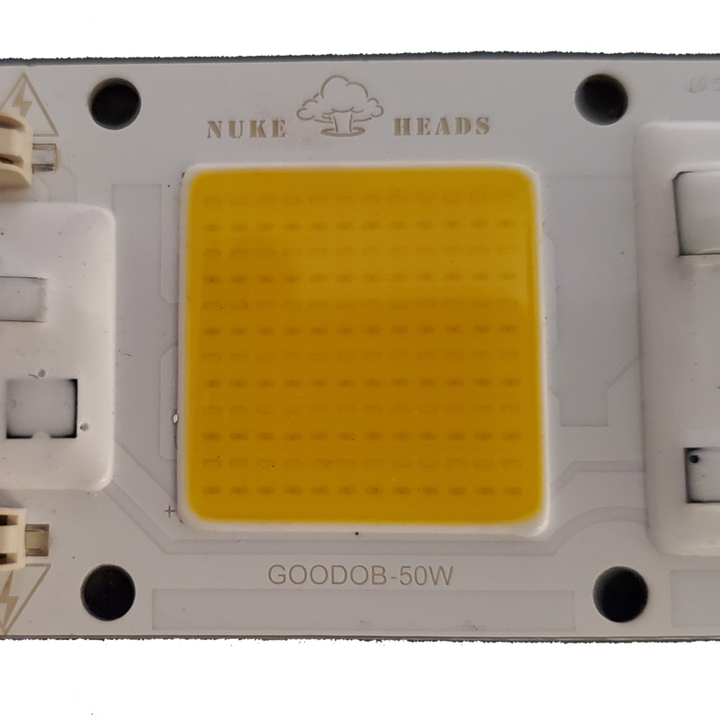 Close-up of a yellow LED chip on a white circuit board.