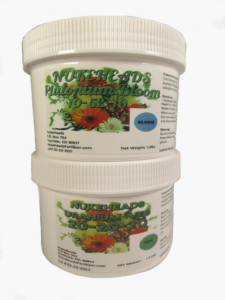 Two white containers of natural fertilizer for plants with colorful labels.